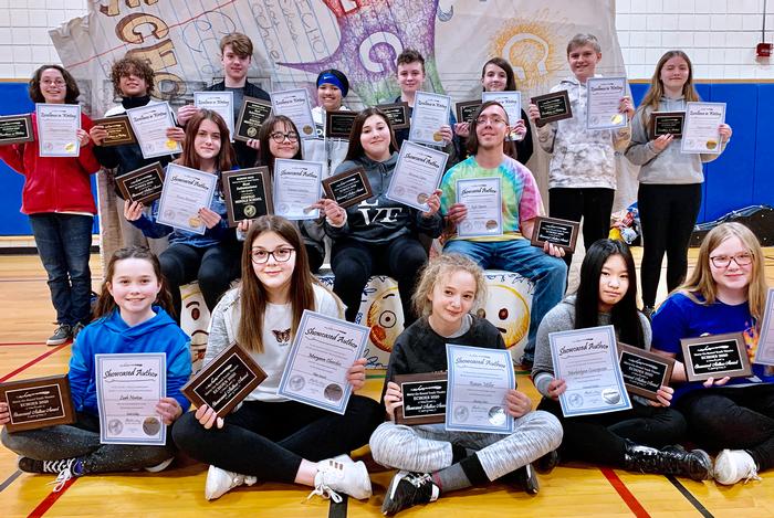 Students holding up awards that were gotten through Writing Competition