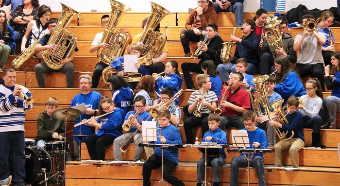 Students Playing Different Musical Instruments sitting on Bleachers