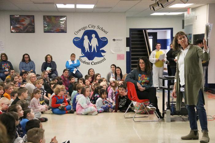 Minetto Teacher Holds Book In Front of Staff and Students