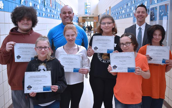 Students with their Teachers Holding Up Pieces of Papers with Awards On Them