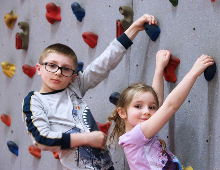 Two Students Climbing Up a Indoor Rock Wall