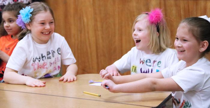 Children Sitting at a Table Laughing