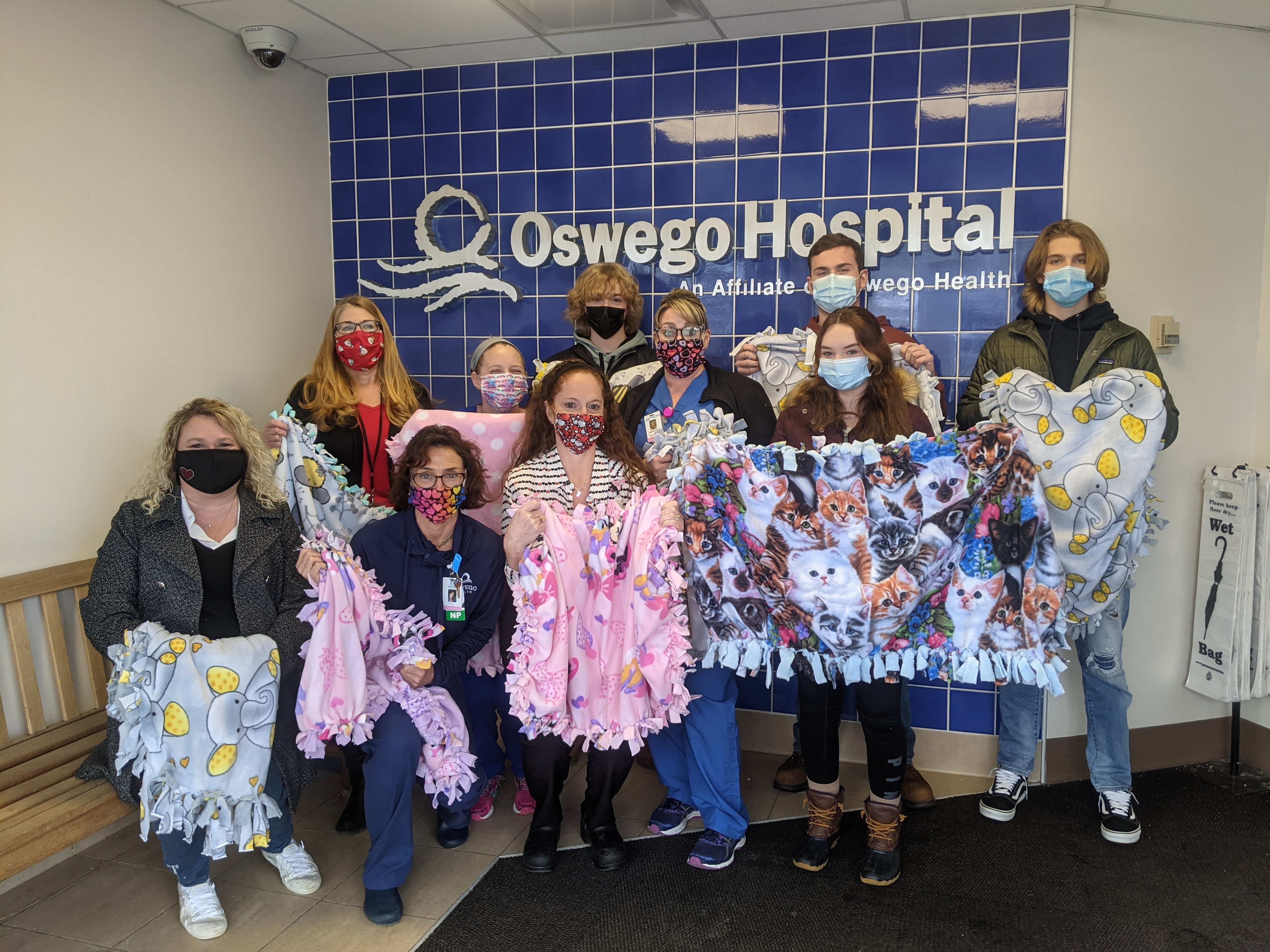 Several members from the Oswego High School Interact Club present a donation of 24 blankets to the maternity ward staff at Oswego Hospital